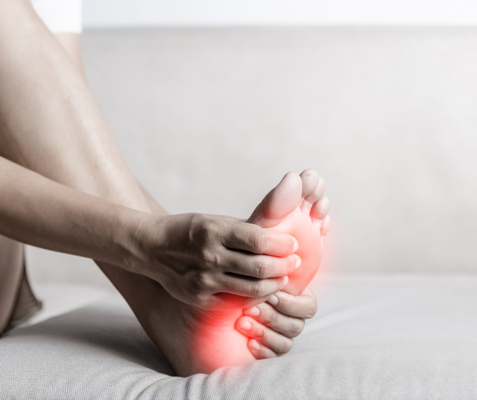 someone holding the bottom of their foot with red circles radiating off the ball of the foot to display pain