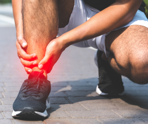 man with ankle arthritis pain hugging his ankle